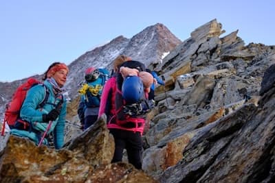Mountaineers ascending a rocky mountain ridge